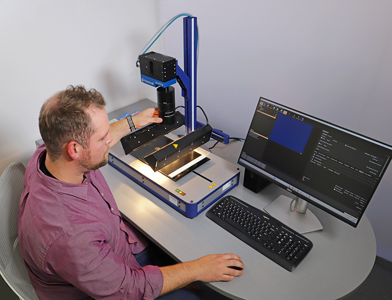 George Killian, Headwall Applications Scientist, adjusts the lens on an MV.C NIR mounted on the perClass Mira Stage while it scans herbs and spices